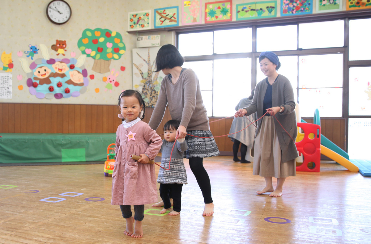 お母さんと子どもが紐を使って遊んでいる様子