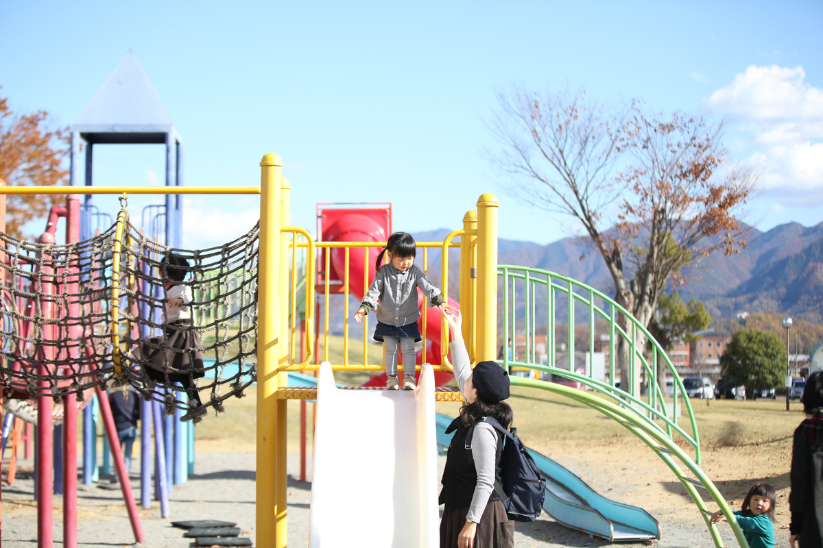 公園の滑り台をこれから滑ろうとしている女の子