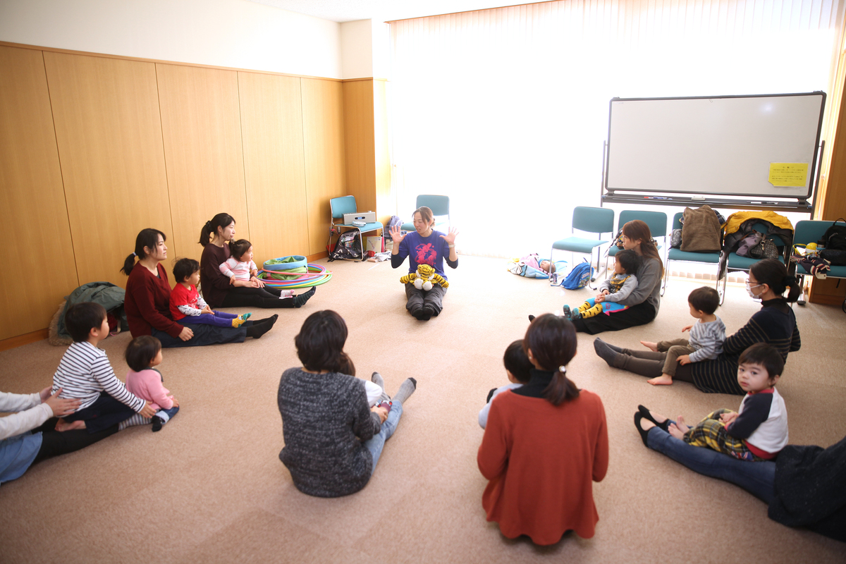 講師の手遊びの様子を見ている親子