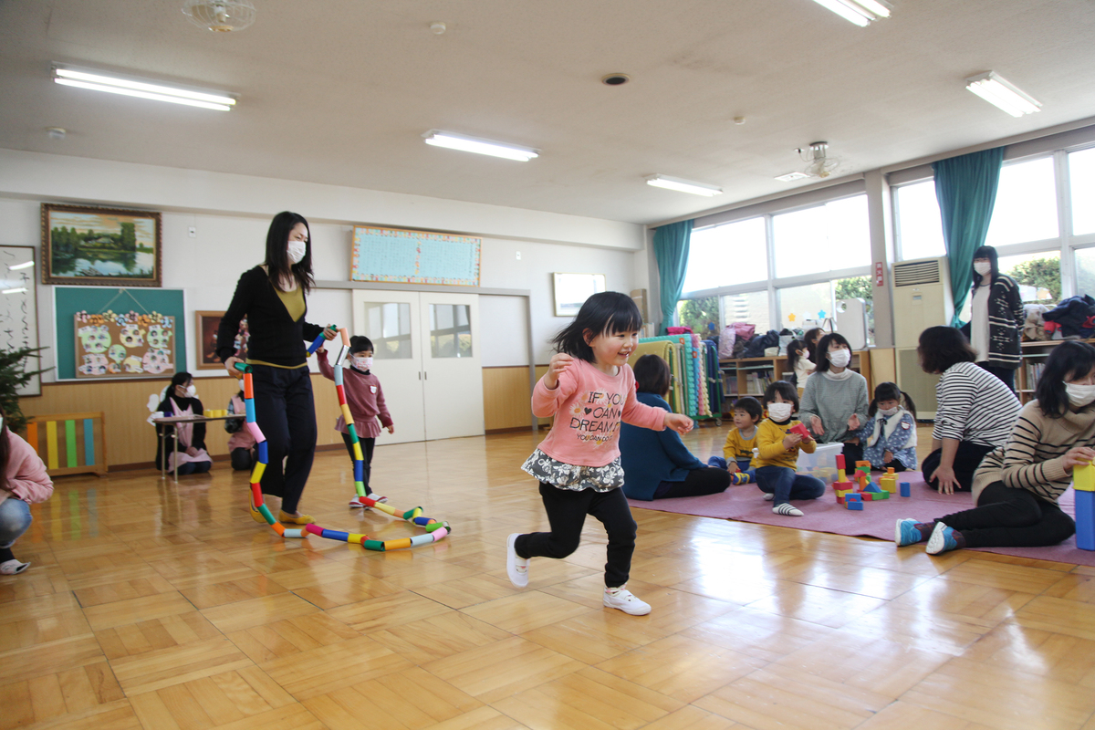 教室を走る女の子の園児や、積み木などで遊んでいる様子
