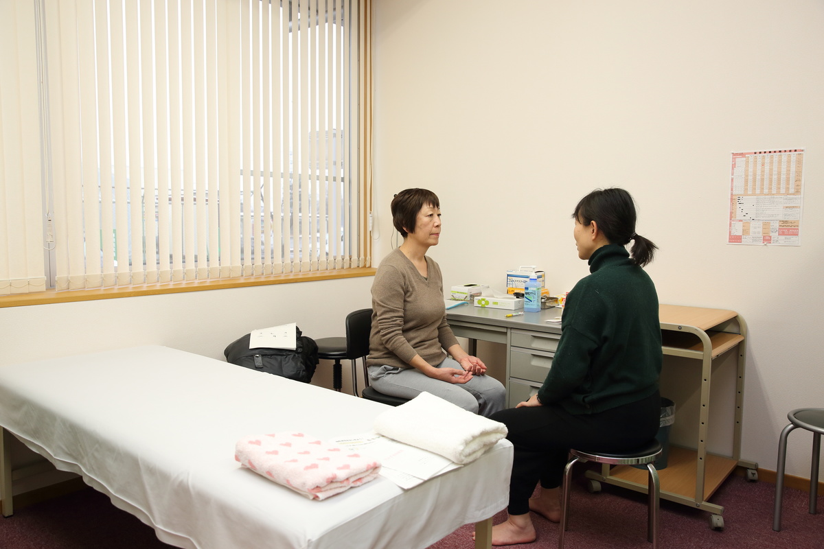 ヨガの講師に女性が相談している様子