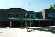 中央市立玉穂生涯学習館の外観写真。なだらかな緑色の屋根のある、茶色に近いグレーの建物です。