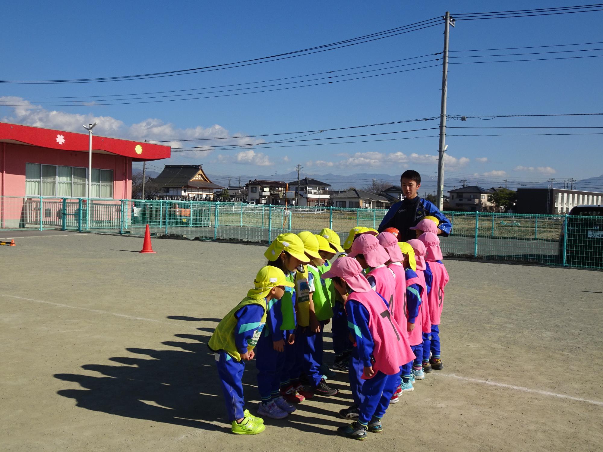 サッカーの試合を始める前に向き合って挨拶を交わす子どもたち