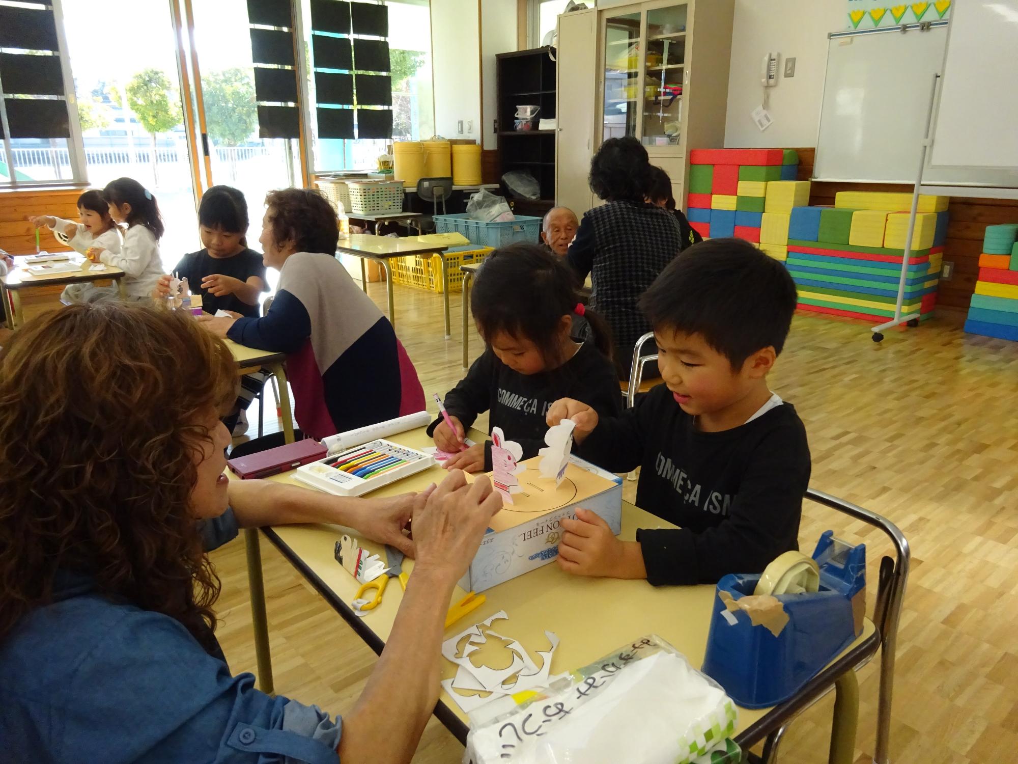 作ったトントン相撲で祖母と遊ぶ年長児