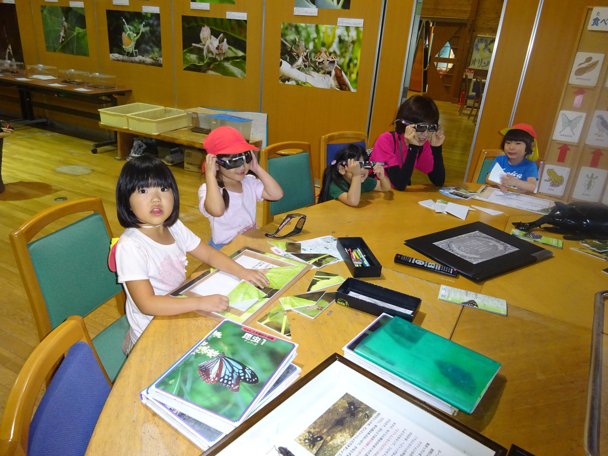 オオムラサキセンター内を見学し、本を読む5歳児の子どもたち