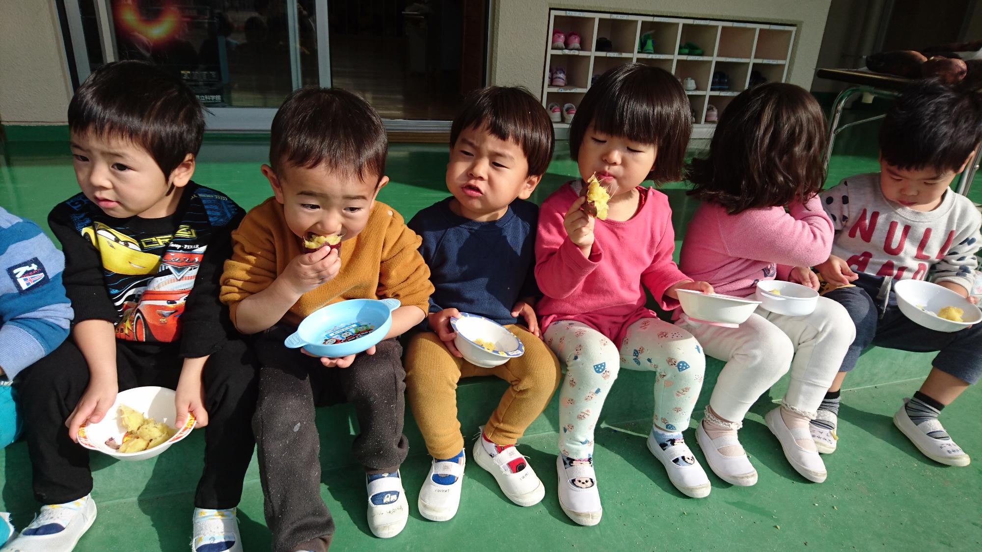 焼い芋を食べる2歳児の子どもたち