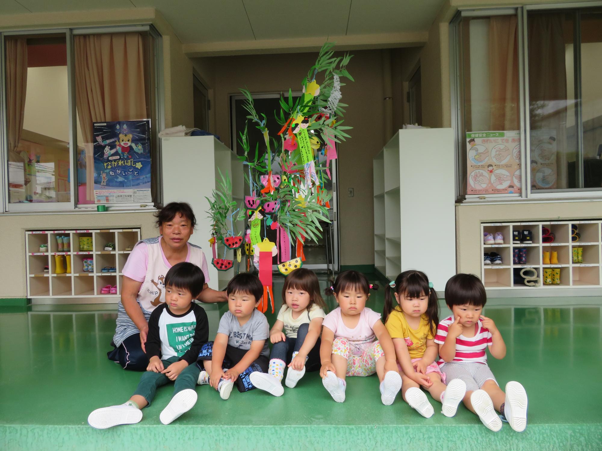 笹飾りの前で集合写真を撮る2歳児の子どもたち