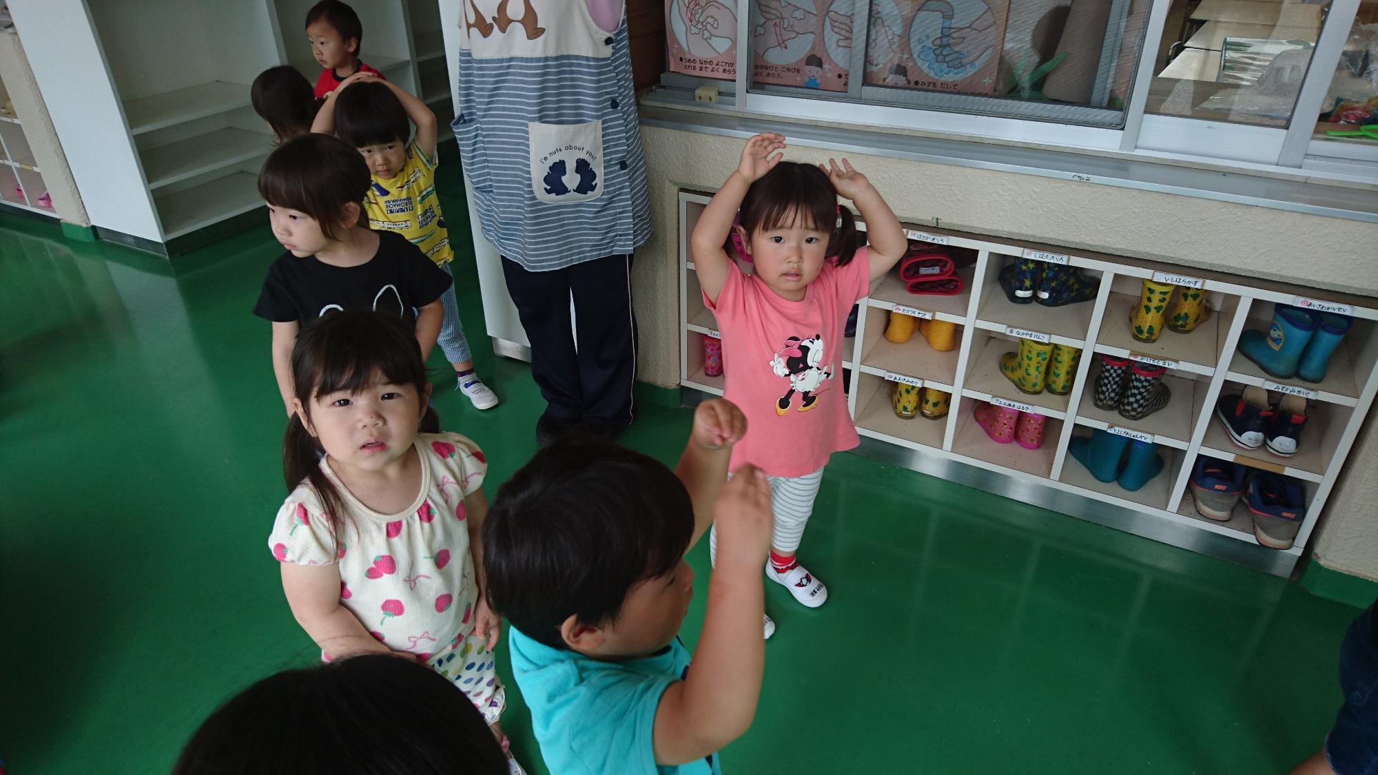 廊下で盆踊りを踊る2歳児の子どもたち