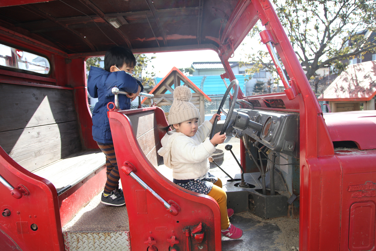 園庭に設置された消防車で遊ぶ子どもたち